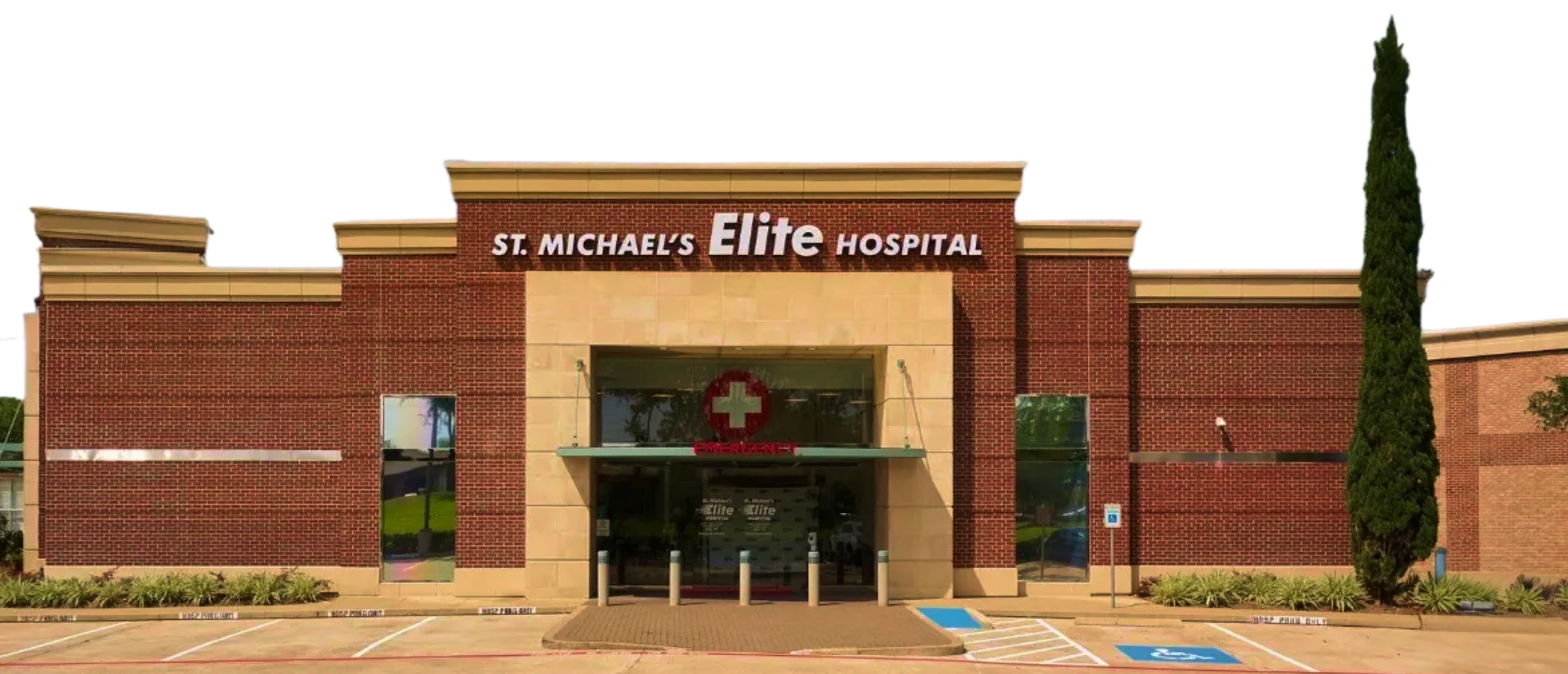 Front view of St. Michael’s Elite Hospital building with emergency entrance, red brick exterior, and accessible parking spaces.