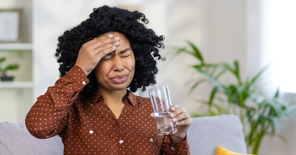 Women experiencing dehydration cause headaches indoors.