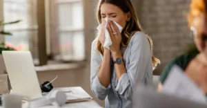 39_young-sick-businesswoman-sneezing-tissue-while-working-office